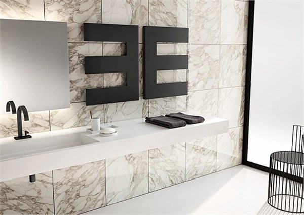 Termoarredo di design nero a forma geometrica su parete effetto marmo