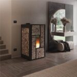 Termostufa con rivestimento in pietra accesa accanto a uno specchio tondo