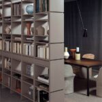 Libreria a tutta altezza usata come divisorio tra soggiorno e zona pranzo