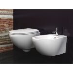 Vaso e bidet sospesi bianchi su una parete scura con lastra effetto onice