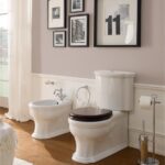Vaso monoblocco e bidet bianchi in un bagno classico con pavimento in legno