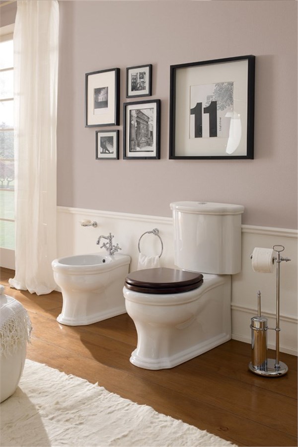 Vaso monoblocco e bidet bianchi in un bagno classico con pavimento in legno