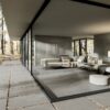 Soggiorno moderno con ampie vetrate, pavimento grigio della Ceramica Del Conca, divani bianchi e luce naturale.