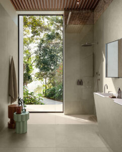 Bagno moderno con doccia walk-in Sensoria Ceramica Del Conca, ampio specchio e porta a vetri che si affaccia sul giardino luminoso.