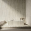 Bagno in stile minimalista con vasca rettangolare rialzata, pannelli in legno chiaro e rivestimento Ceramica Del Conca Marble Edition.