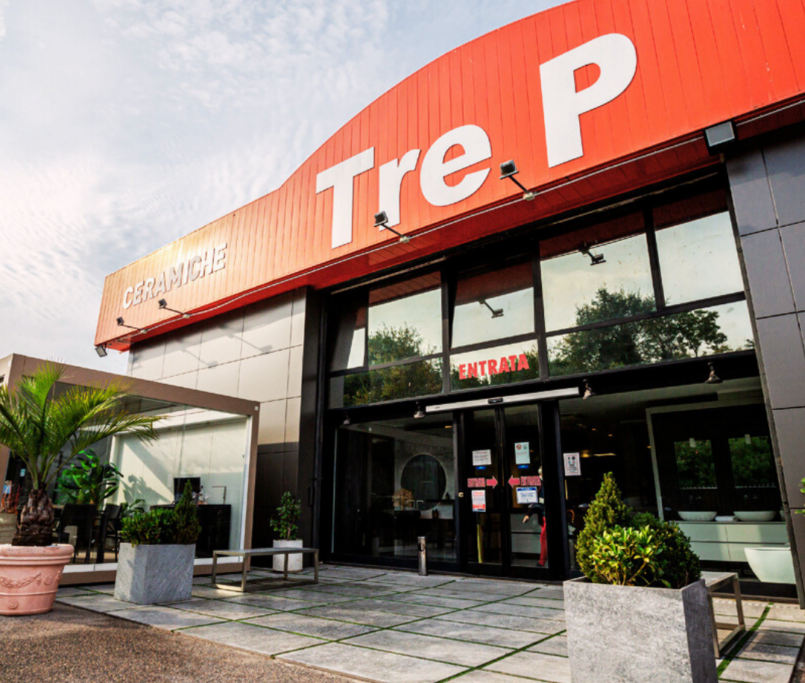 Ingresso Tre P CERAMICHE con insegna rossa, porte a vetri e piante all’ingresso.